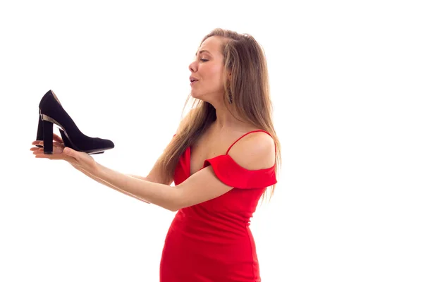 Young woman in red dress holding shoes — Stock Photo, Image