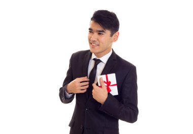 Bir hediye tutan takım elbiseli genç adam