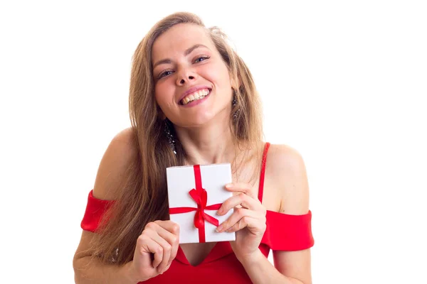 Молодая женщина в красном платье держит подарок — стоковое фото
