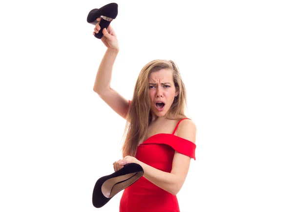 Mladá žena v červených šatech, držící boty — Stock fotografie