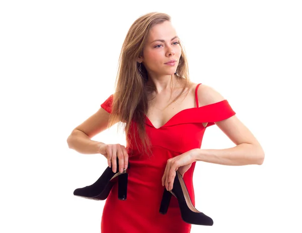 Jovem mulher de vestido vermelho segurando sapatos — Fotografia de Stock