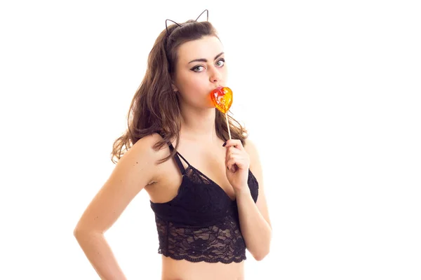 Молода жінка в чорному бюстгальтері з цукерками — стокове фото