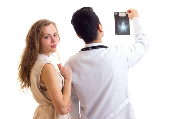 Doctor mostrando rayos X a una mujer joven — Foto de Stock