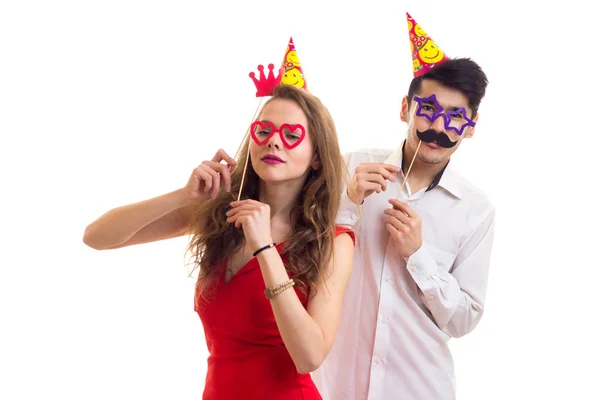 Pareja joven con palos de cartas y sombreros de celebración — Foto de Stock