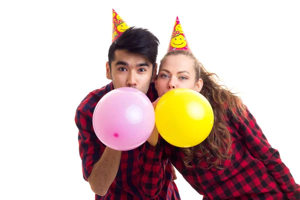 Jovem casal soprando balões — Fotografia de Stock