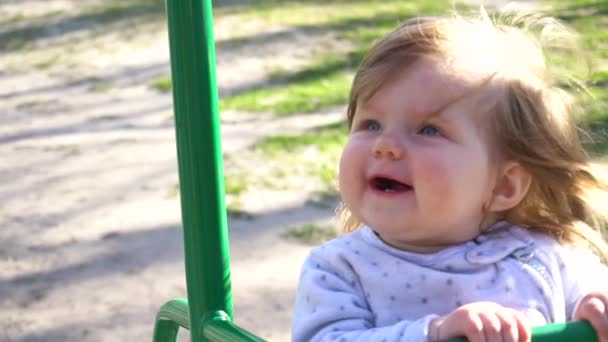 Schattige schattig babymeisje op schommel in zomertijd in slowmo — Stockvideo