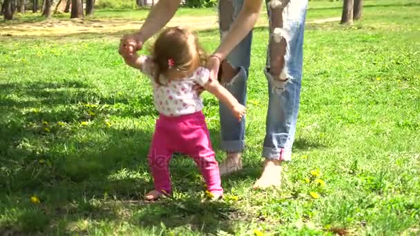 Premiers pas de bébé fille marchant dans le parc — Video