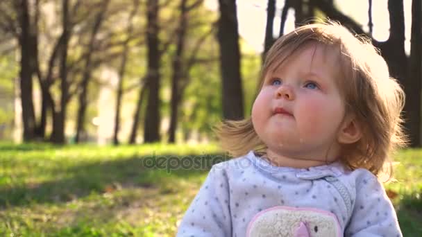 Babymeisje in het park en glimlachen — Stockvideo