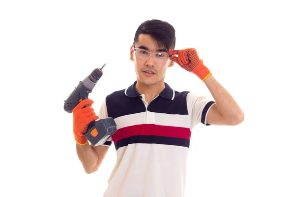 Jonge man met handschoenen en bril houden van elektrische schroevendraaier — Stockfoto