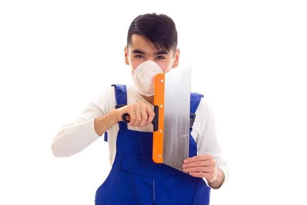 Homem de azul em geral com respirador segurando espátula — Fotografia de Stock