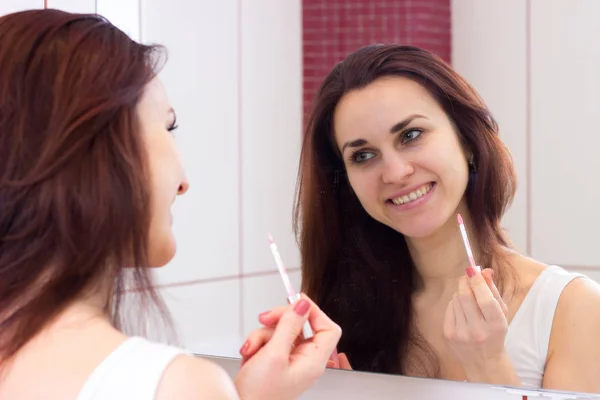 Joven mujer labio brillante en el baño — Foto de Stock