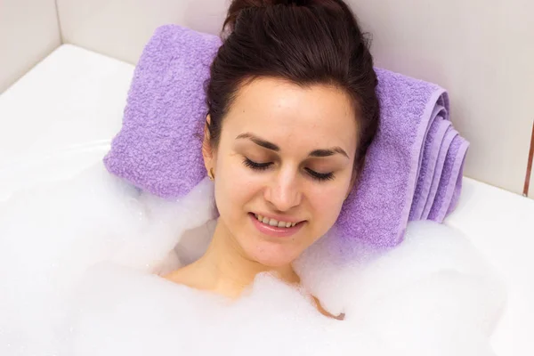 Jonge vrouw liggend in de bad — Stockfoto