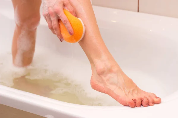 Young woman washing with sponge in the bath — Stock Photo, Image