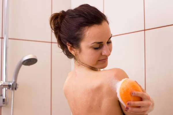 Jeune femme lavage avec éponge dans la douche — Photo