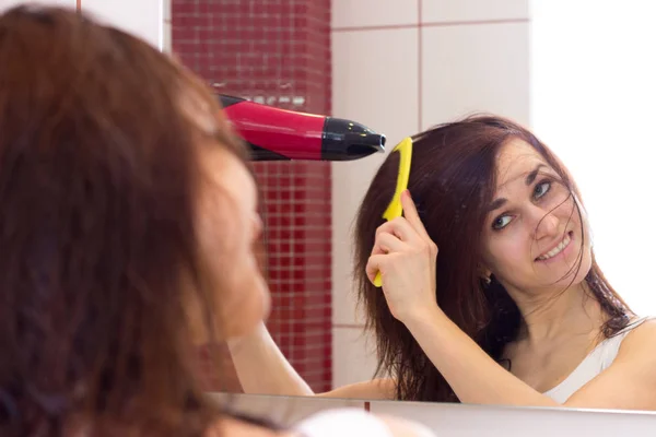 Mujer joven secándose el pelo en el baño —  Fotos de Stock