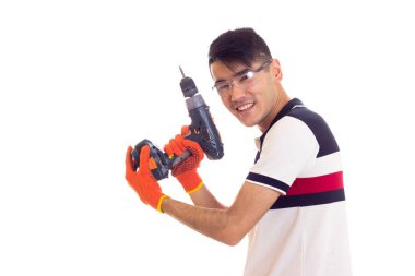 Eldiven ve gözlük elektrikli tornavida tutan genç adamla