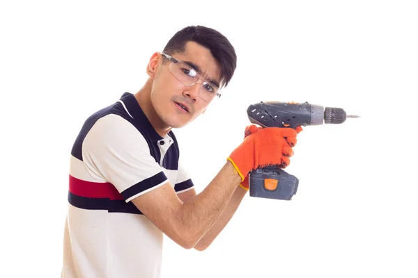 Jonge man met handschoenen en bril houden van elektrische schroevendraaier — Stockfoto