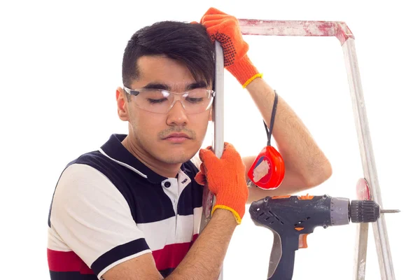 Jonge man met elektrische schroevendraaier en ledder — Stockfoto