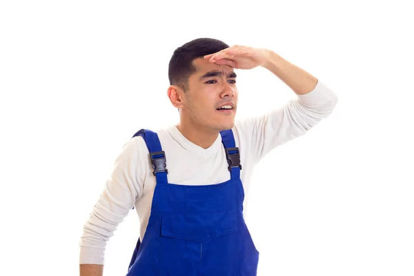 Jonge man in blauwe overall op zoek op afstand — Stockfoto