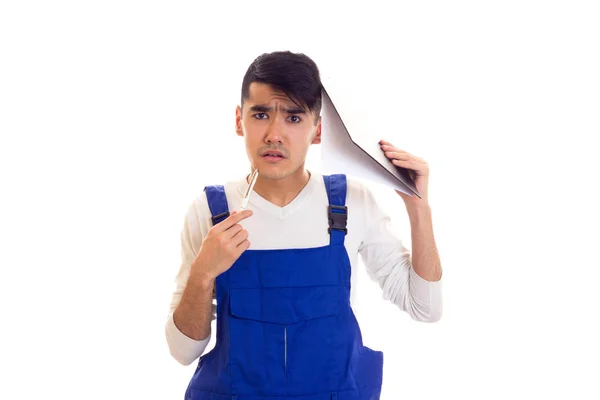 Молодий чоловік в блакитному в цілому тримає ручку і теку — стокове фото