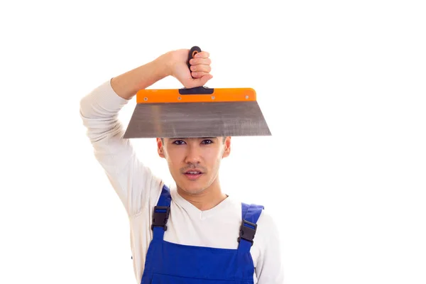 Man in blue overall holding spatula — Stock Photo, Image