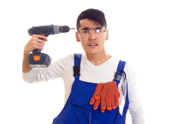 Man in overall with gloves and glasses holding electric screwdriver — Stock Photo, Image