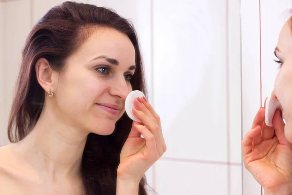 Fiatal nő eltávolítja a smink a fürdőszobában — Stock Fotó
