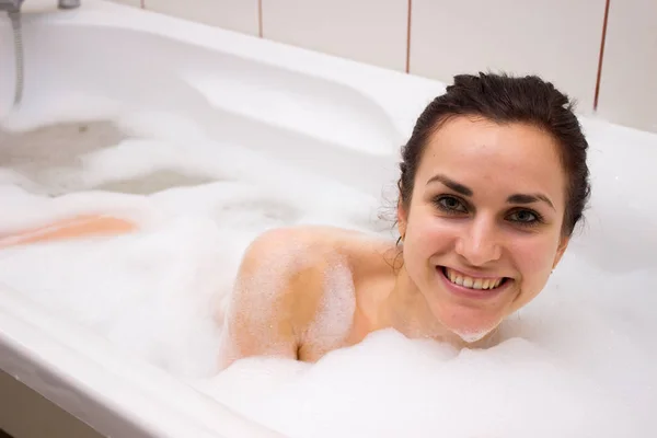Ung kvinna ligga i badet — Stockfoto