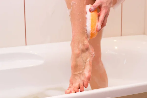 Mujer joven lavando con esponja en el baño —  Fotos de Stock