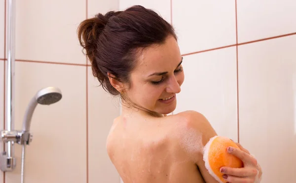 Jeune femme lavage avec éponge dans la douche — Photo