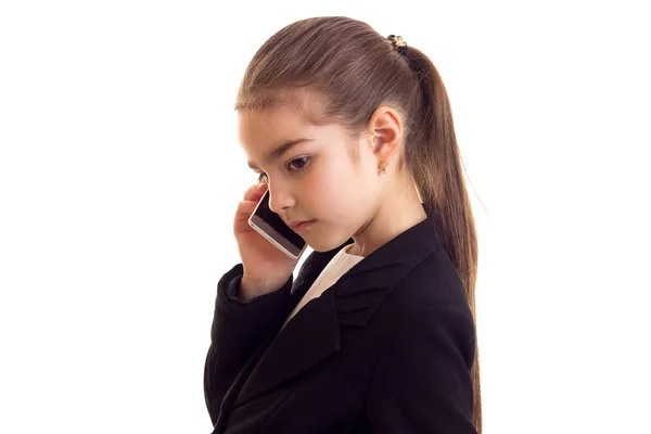 Malá holčička v černé bundě mluví po telefonu — Stock fotografie