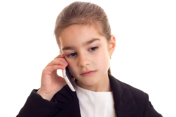 Klein meisje in zwarte jas praten over telefoon — Stockfoto