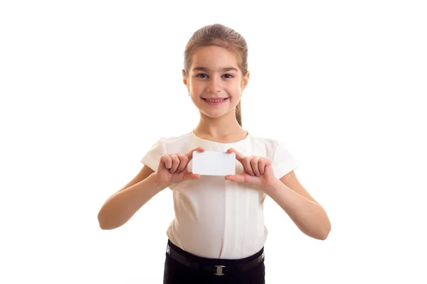 Little girl in white T-shirt holding white card — Stock Photo, Image