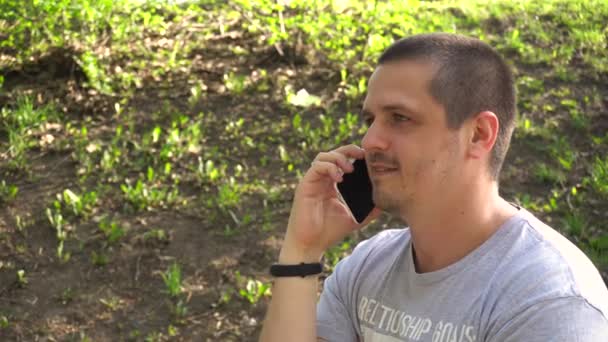 Мужчина разговаривает со своим смартфоном — стоковое видео