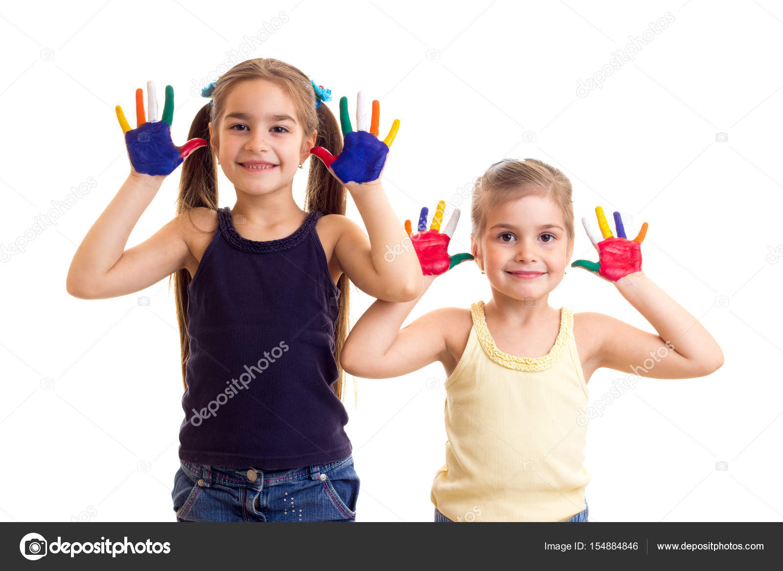 Due bambine carine in camicie nere e gialle con code di cavallo e mani colorate su fondo bianco in studio — Foto di Dmitroza Trova immagini simili