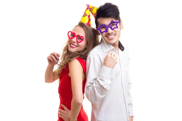 Jeune couple avec bâtons de cartes et chapeaux de fête — Photo