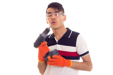 Eldiven ve gözlük elektrikli tornavida tutan genç adamla