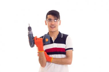 Eldiven ve gözlük elektrikli tornavida tutan genç adamla