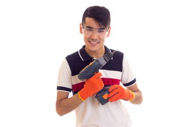 Eldiven ve gözlük elektrikli tornavida tutan genç adamla