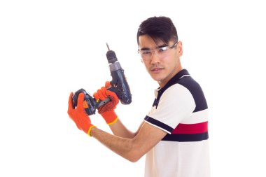 Eldiven ve gözlük elektrikli tornavida tutan genç adamla