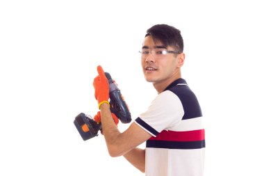 Eldiven ve gözlük elektrikli tornavida tutan genç adamla