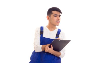 Mavili genç adam elinde kalem ve klasör tutuyor.