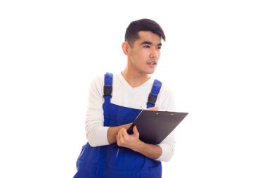 Mavili genç adam elinde kalem ve klasör tutuyor.