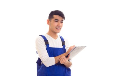 Mavili genç adam elinde kalem ve klasör tutuyor.