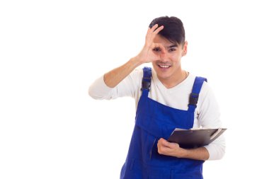 Mavili genç adam elinde kalem ve klasör tutuyor.