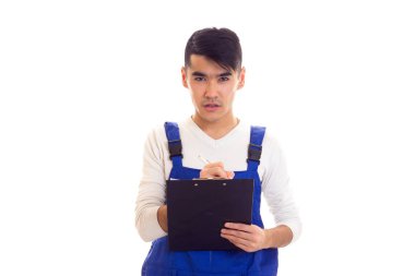 Mavili genç adam elinde kalem ve klasör tutuyor.