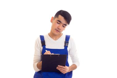 Mavili genç adam elinde kalem ve klasör tutuyor.