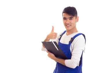 Mavili genç adam elinde kalem ve klasör tutuyor.