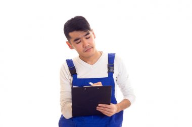 Mavili genç adam elinde kalem ve klasör tutuyor.