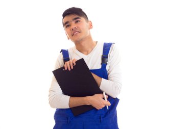 Mavili genç adam elinde kalem ve klasör tutuyor.